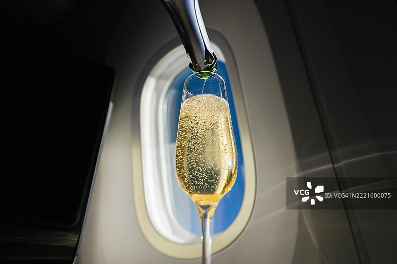 飞机窗户旁的香槟瓶和酒杯图片素材