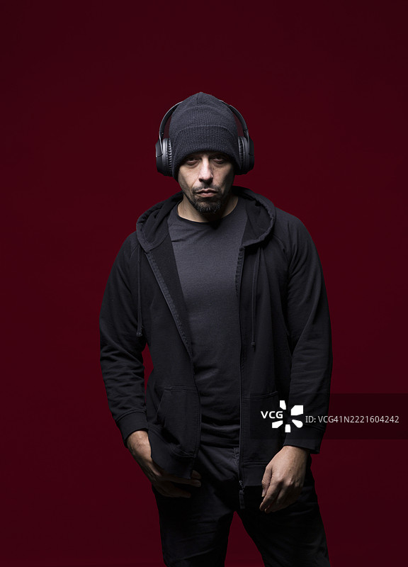 戴着耳机、穿着深色衣服的男人图片素材
