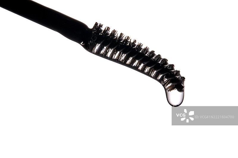 眉毛和睫毛生长油从黑色刷子中流出。图片素材