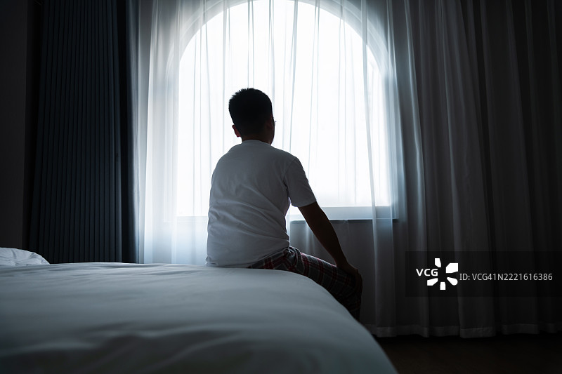 少年男孩坐在床上的背影图片素材