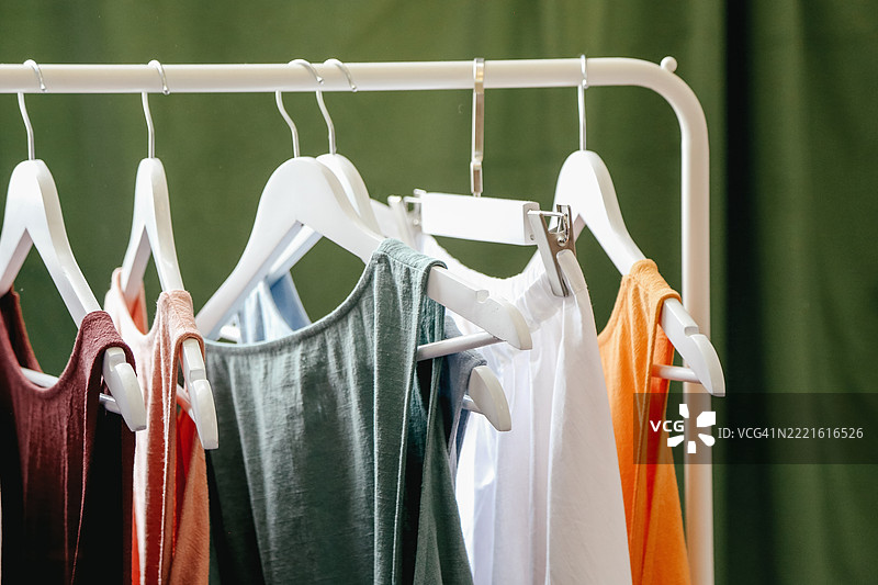 优雅的丝绸和棉质夏裙在衣架上的服装店，满幅画面，环境光线柔和图片素材