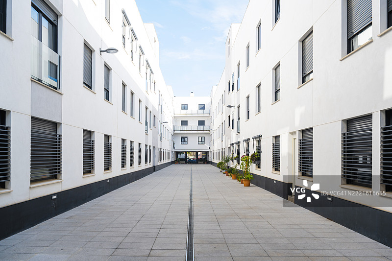 现代住宅建筑，干净的白色外立面和户外小道景观，西班牙塞维利亚图片素材