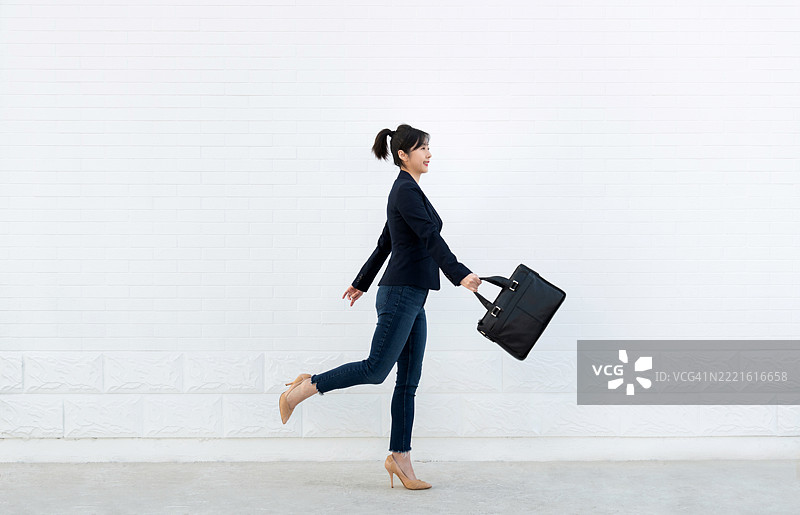 自信的女性走路时手持公文包图片素材
