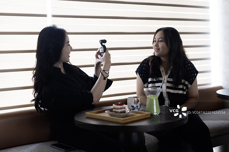 年轻的亚洲女孩一起拍摄视频博客图片素材