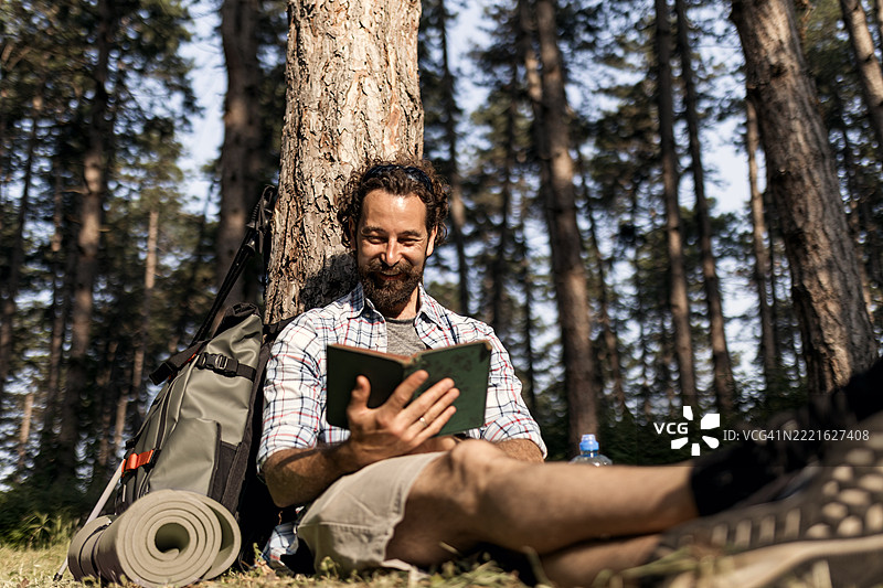 夏季公园中阅读书籍的徒步旅行者图片素材