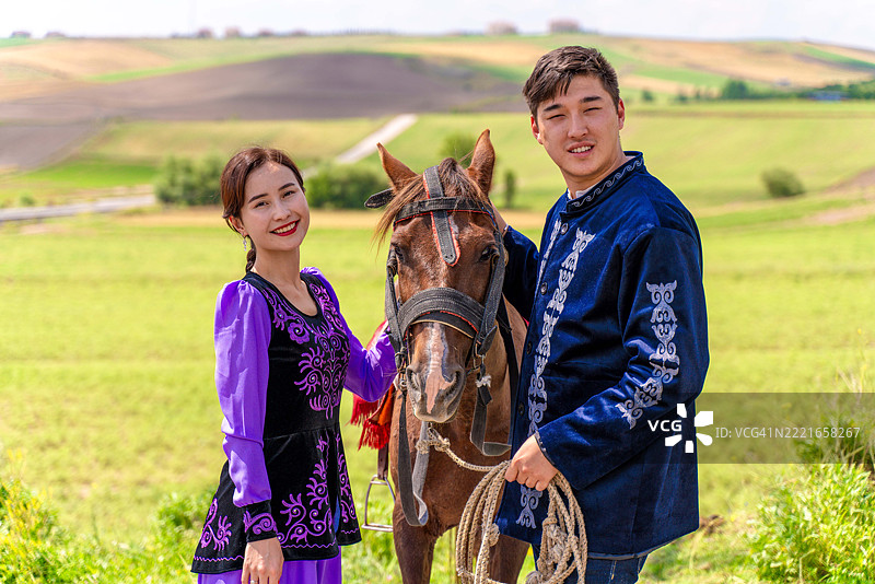 穿着传统中亚服装的情侣在蒙古包前合影图片素材