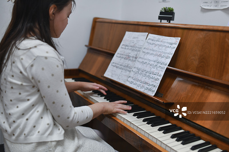 专注练习新钢琴曲的美丽女孩图片素材