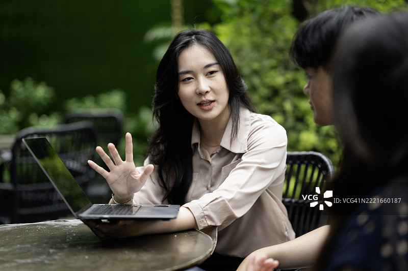 年轻的亚洲女性正在向朋友们做演讲图片素材