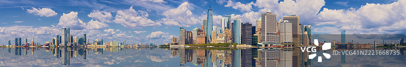 纽约市天际线，包含泽西市、曼哈顿金融区、世贸中心、布鲁克林和曼哈顿大桥，以及蓝天和白云。图片素材