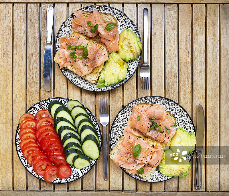 木桌上的烟熏三文鱼和鳄梨开放式三明治图片素材