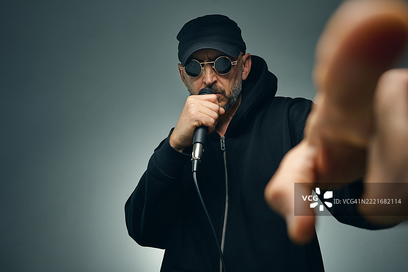 充满激情的音乐家对着麦克风唱歌并指向你图片素材