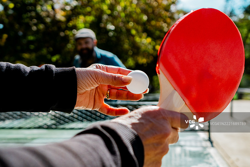 户外乒乓球比赛中，女子准备发球的特写镜头图片素材