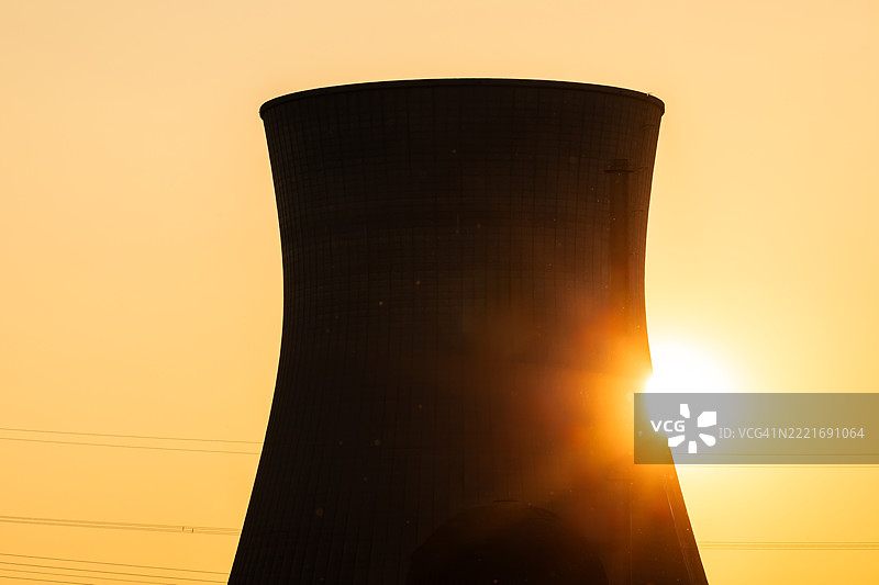 核电站的冷却塔在日落时分的明亮阳光下图片素材
