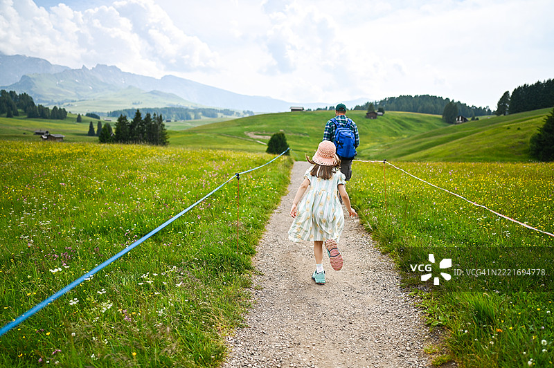 父亲和女儿在意大利阿尔卑斯山徒步旅行，享受夏季假期图片素材