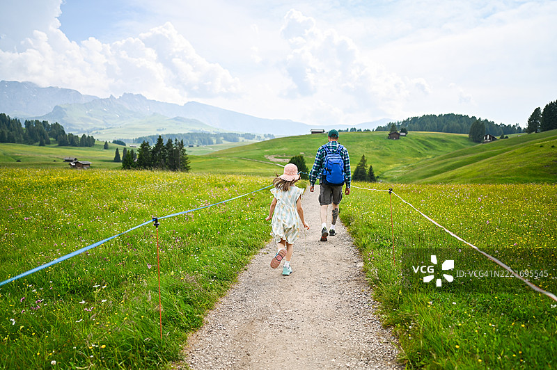 父亲和女儿在意大利阿尔卑斯山徒步旅行，享受夏季假期图片素材