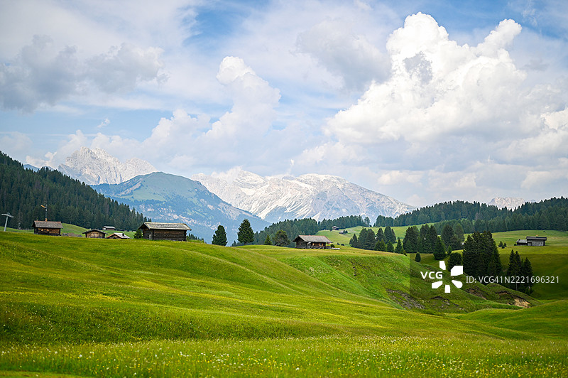 令人惊叹的阿尔卑斯风光，绿草如茵的草甸和多洛米蒂山脉的传统木屋图片素材