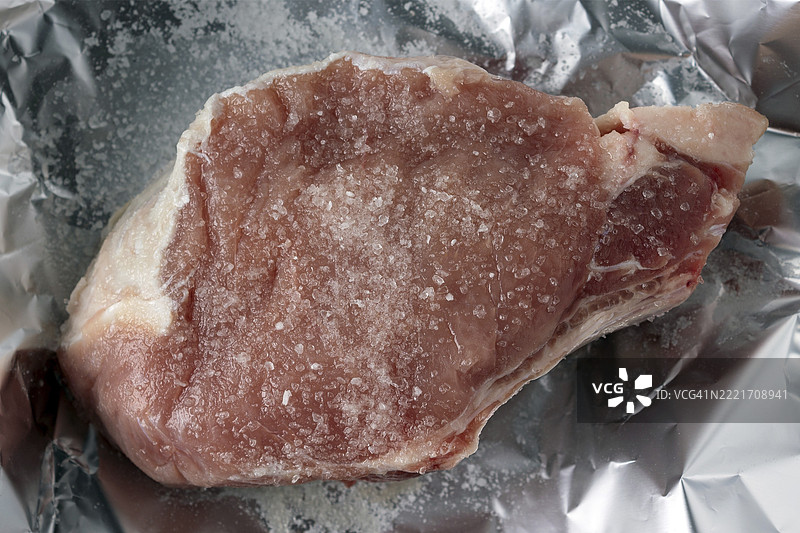 一块盐渍猪肉放在锡纸上，特写，俯视图图片素材