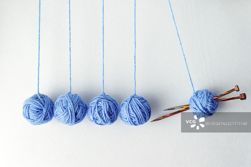 用蓝色毛线球制作的牛顿摆，留白，创意照片图片素材