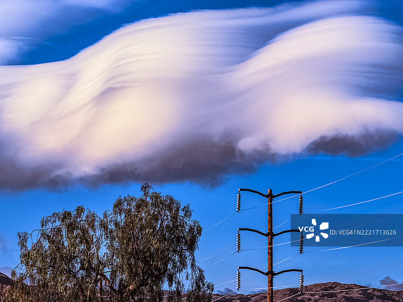 加州兰乔米拉奇的树木和电力线上的透镜云形成图片素材
