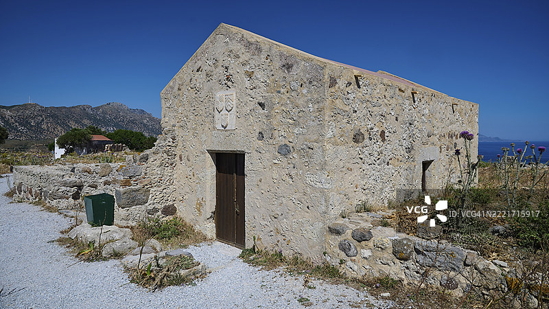 科斯岛安提马希亚的 Agios Nikolaos 小教堂,地中海风景中的古老石头房屋,背景是蔚蓝的天空,安提马希亚,圣约翰堡垒,科斯岛,佐泽卡尼索斯群岛,希腊群岛,希腊,欧洲图片素材