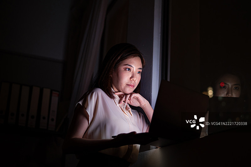 年轻的亚洲女性在深夜专注于她的工作图片素材