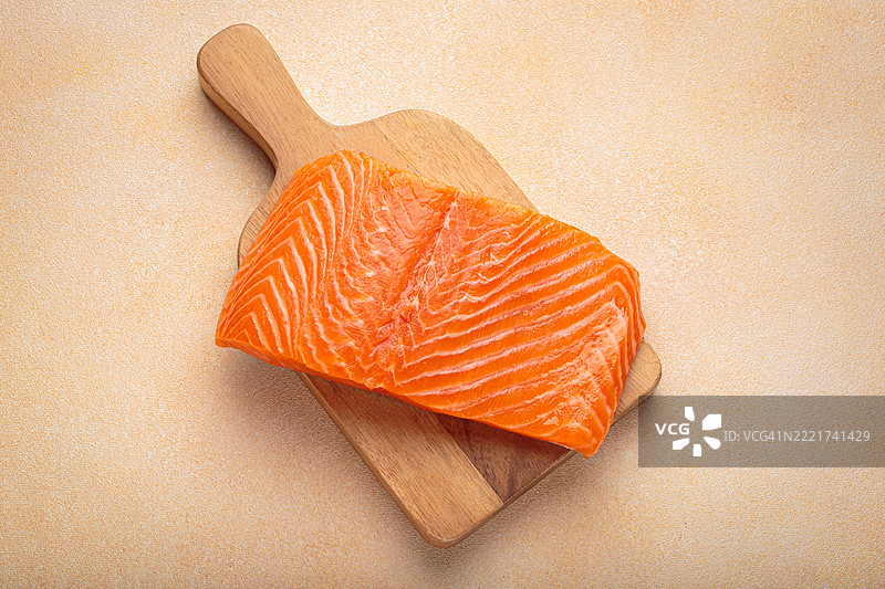 新鲜的三文鱼片在切菜板上，美味又健康的餐点图片素材