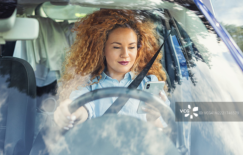 美丽的女性在驾驶时分心图片素材