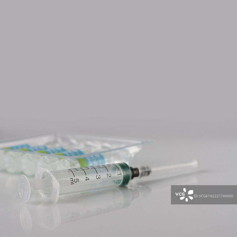 一次性注射器和安瓿包装在白色玻璃上，疫苗药物，空间的副本图片素材