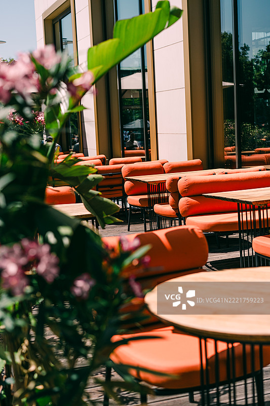 户外座位区，配有鲜艳的橙色椅子，俯瞰绿意盎然的景色图片素材