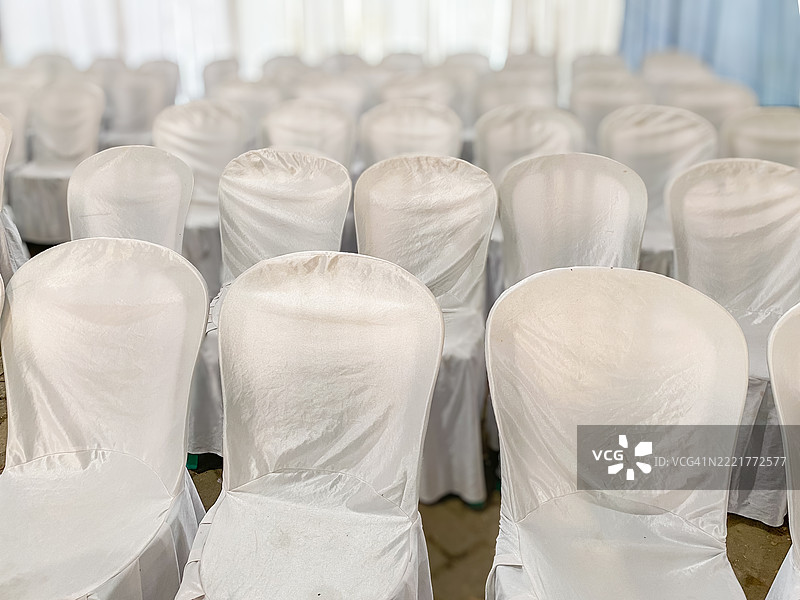覆盖着白色布料的椅子排成行图片素材