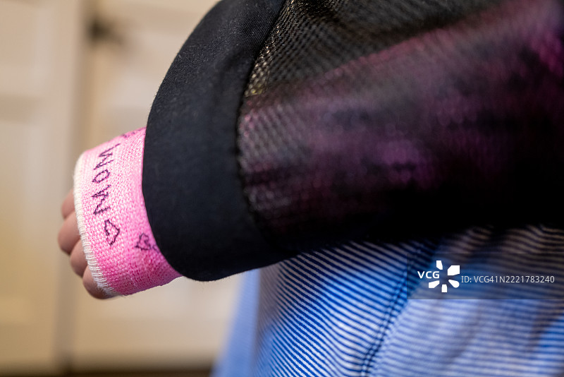 年轻的多种族女孩，手臂上有粉色的石膏和吊带。图片素材