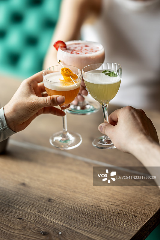 朋友们在酒吧或餐厅举杯庆祝鸡尾酒图片素材