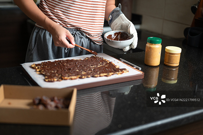 在家准备巧克力零食，配有坚果和花生酱的女性图片素材