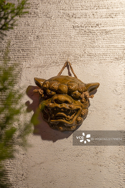 横滨餐厅墙上的冲绳陶瓷狮子面具图片素材