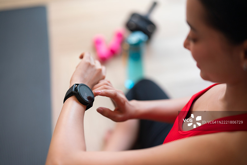 女性在锻炼后查看智能手表的特写镜头图片素材