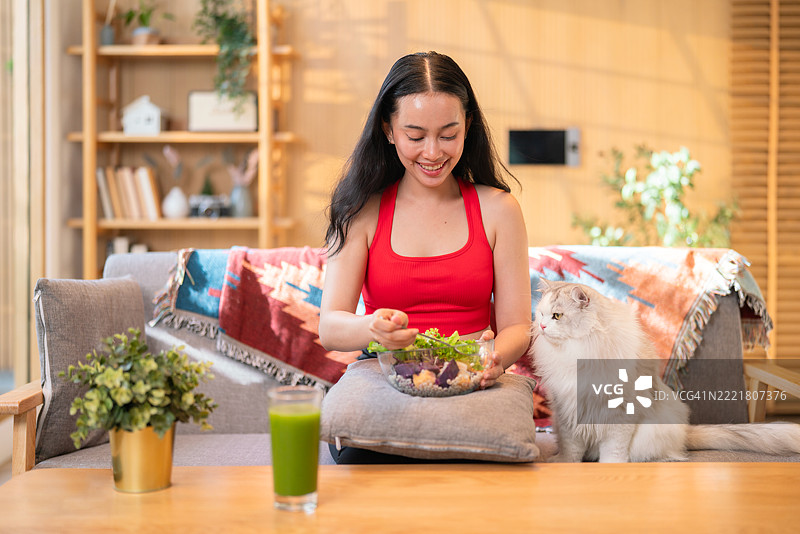 女人与宠物猫一起享用健康沙拉图片素材