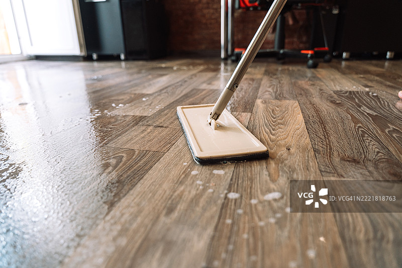 湿润的层压地板特写，正在用泡沫和水进行深度清洁。图片素材