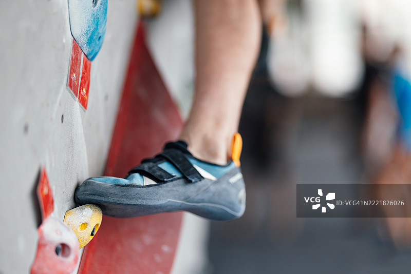 室内攀岩馆中攀岩者脚部特写在墙上的画面图片素材