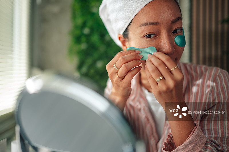 年轻女性在护肤过程中使用眼部贴片图片素材