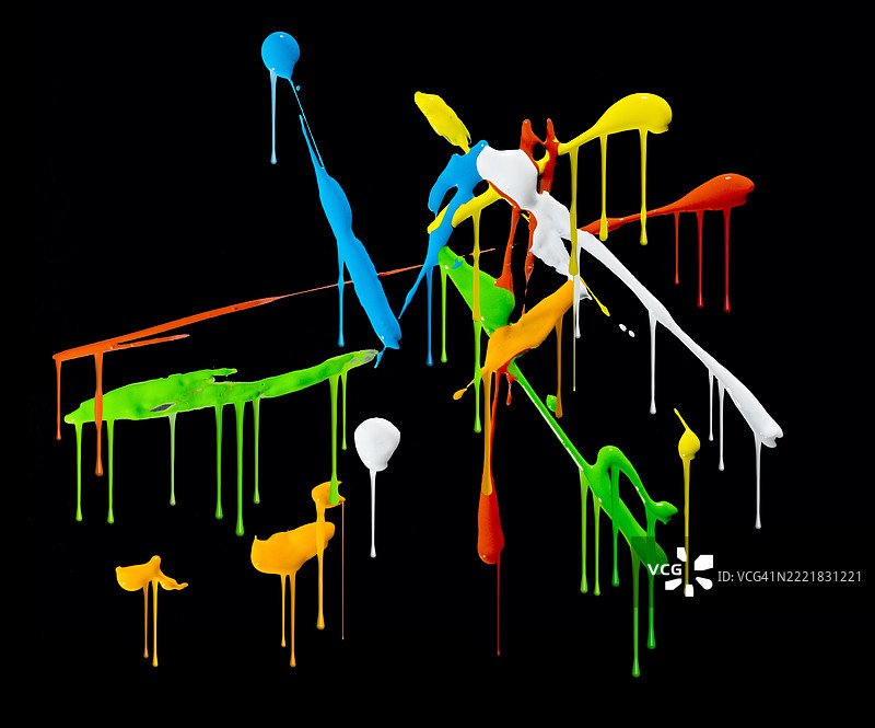 彩色油漆的笔触从黑色墙壁上滴落。图片素材