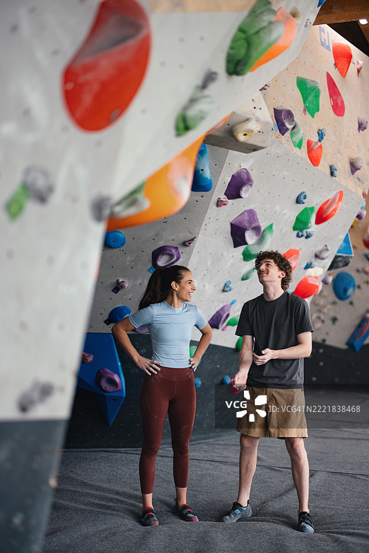 两个朋友在充满活力的室内攀岩馆享受攀岩活动图片素材