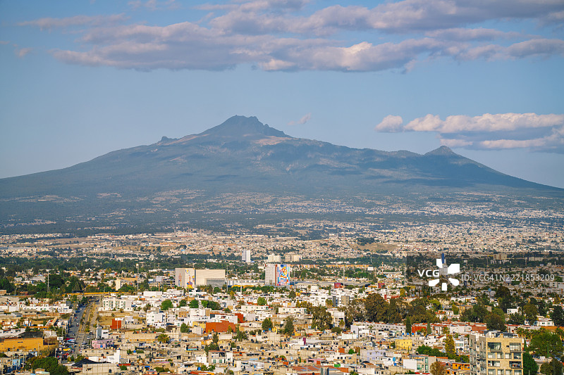 墨西哥普埃布拉州的乔卢拉全景，背景是伊斯塔西瓦特尔火山图片素材