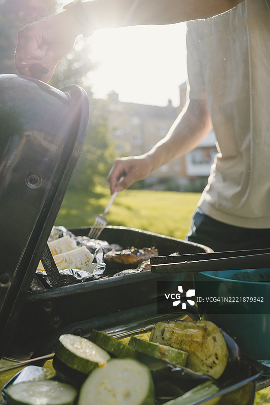 男子在后院烧烤的中段身影图片素材