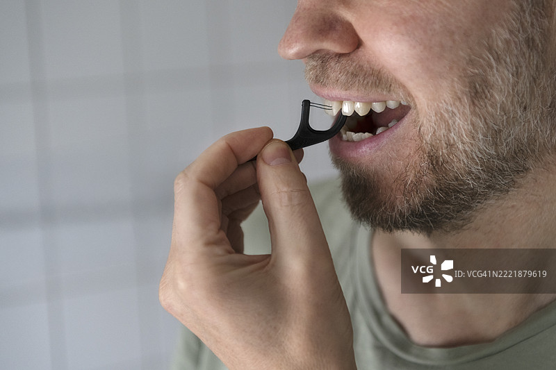 男子在浴室里使用牙线的特写镜头图片素材