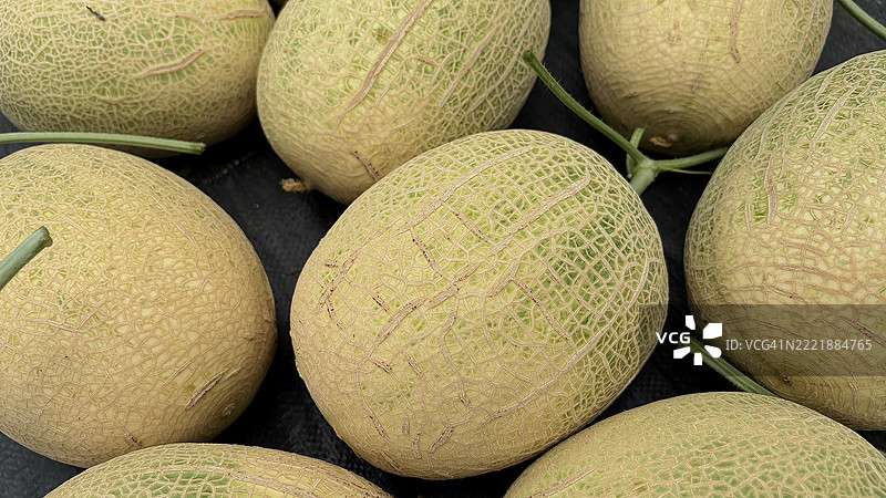 一组成熟的哈密瓜在收获后展示，展现自然的表面纹理。非常适合农业、营养和农场到餐桌的主题。图片素材