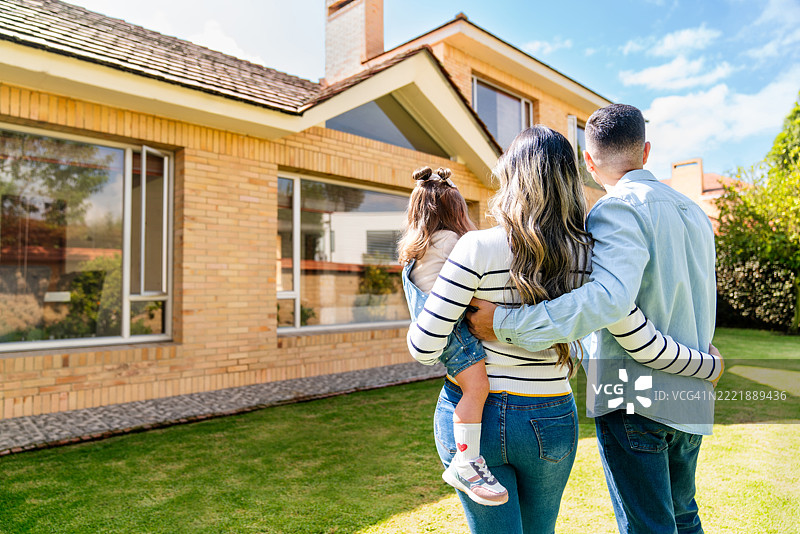 一家人在户外欣赏他们的新房子图片素材