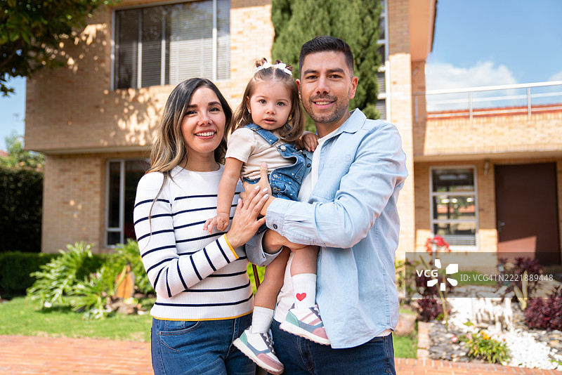 快乐的家庭在新房子前微笑图片素材