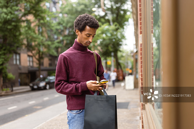 独自购物者在户外查看手机图片素材