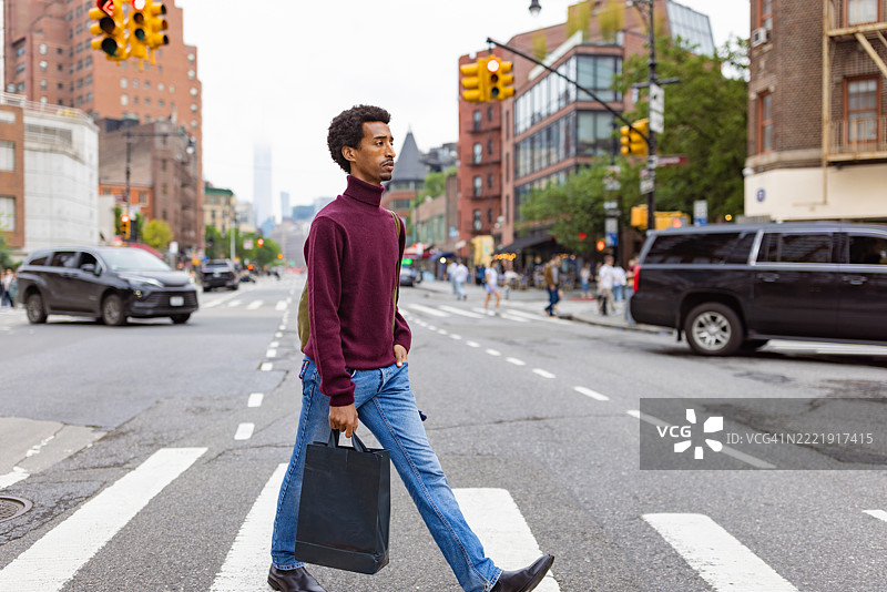 休闲男子穿越城市街道图片素材