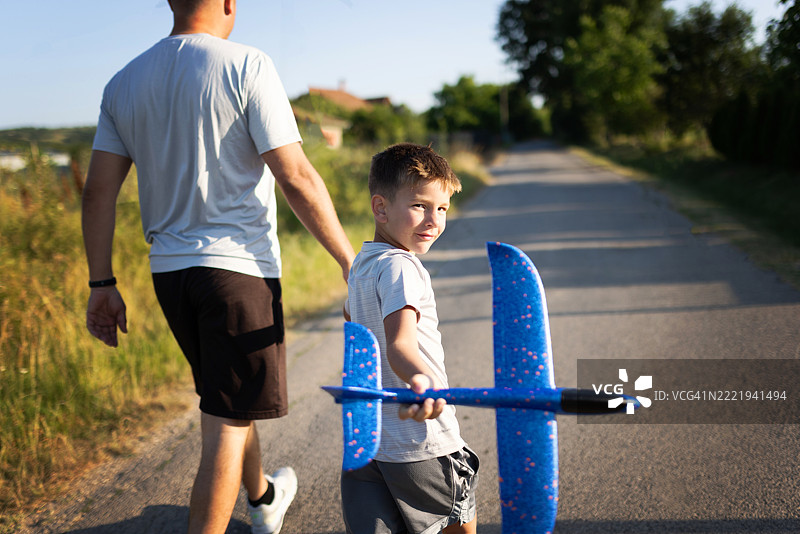 父亲和儿子享受户外玩具飞机冒险图片素材